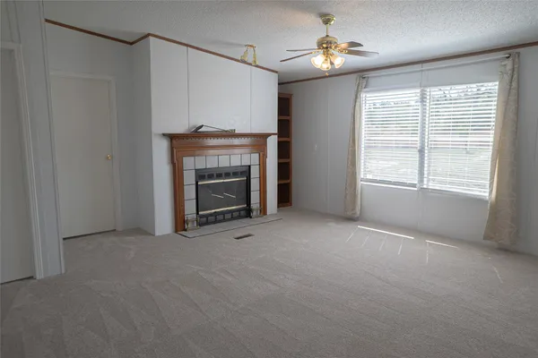 a view of empty room with fireplace and fan