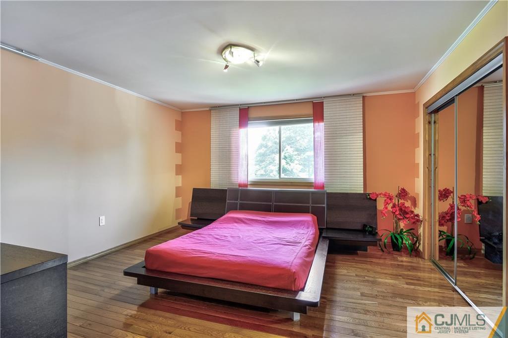221 North Hill Road Colonia, NJ 07067 - Photo 17 of 25 a bedroom with a bed a chandelier and a window