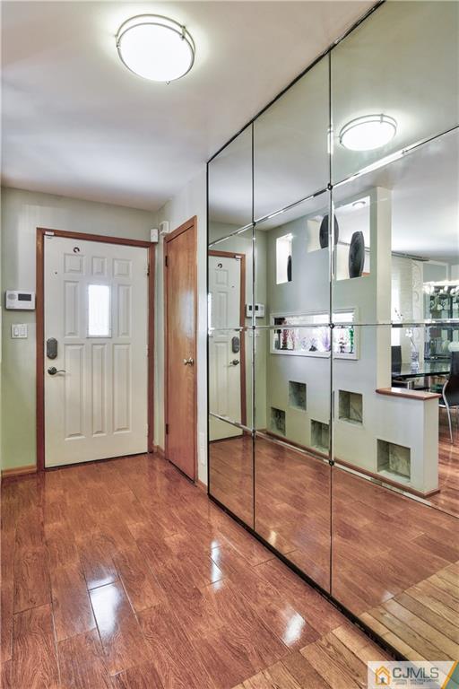 221 North Hill Road Colonia, NJ 07067 - Photo 4 of 25 a view of a hallway with wooden floor and a kitchen