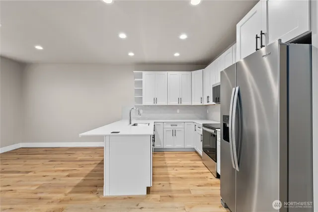 a kitchen with stainless steel appliances a refrigerator sink and microwave