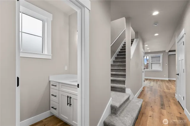 a view of hallway with stairs and wooden floor