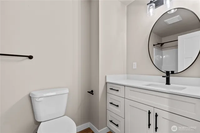 a bathroom with a toilet a sink and mirror