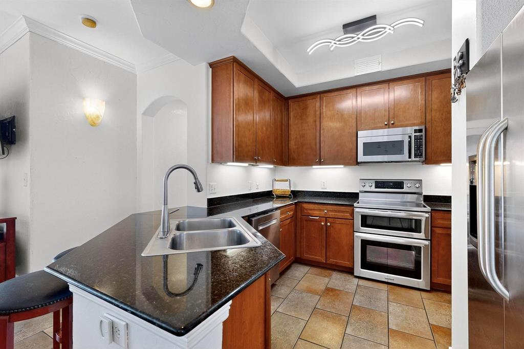 330 Las Colinas Boulevard East, Unit 1116 Irving, TX 75039 - Photo 8 of 36 a kitchen with granite countertop a stove sink and refrigerator