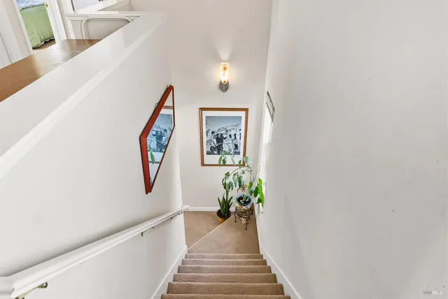 a view of a hallway with wooden floor and stairs