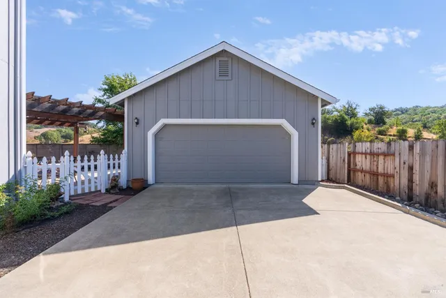 a view of backyard of house with wooden fence