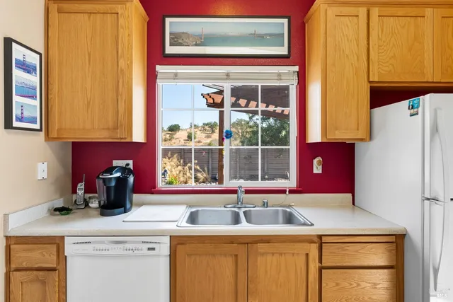 a kitchen with a sink a refrigerator and window