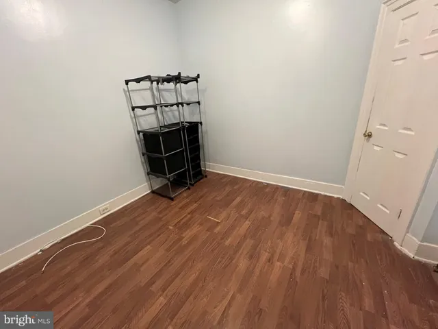 an empty room with wooden floor and white walls