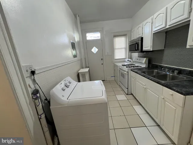 a kitchen with a sink a stove and cabinets