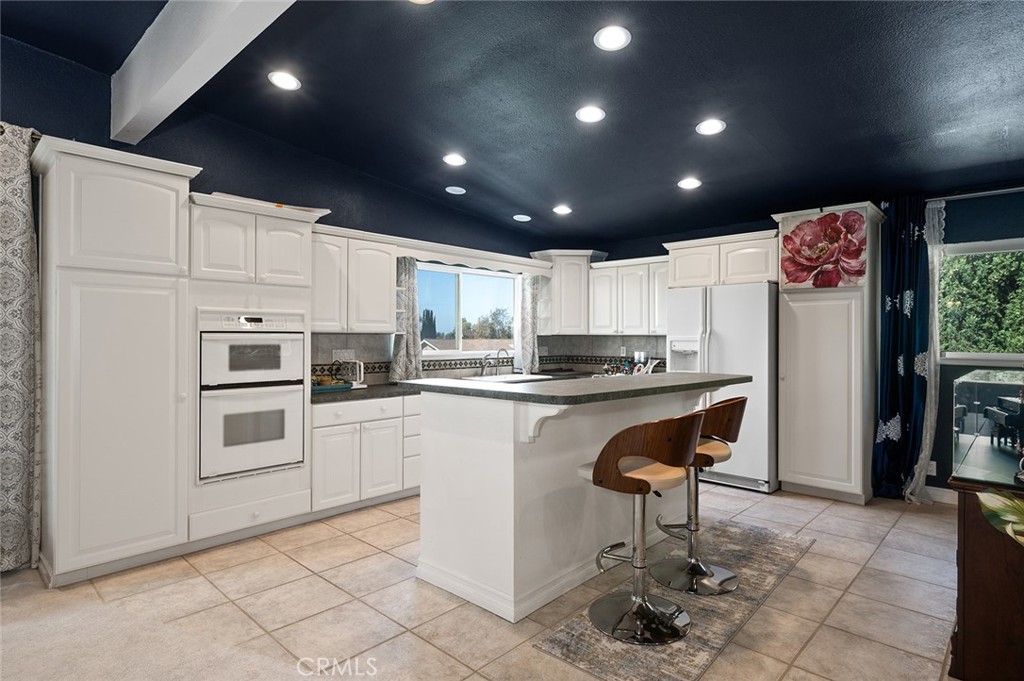 15241 Lille Circle Irvine, CA 92604 - Photo 24 of 38 a kitchen with stainless steel appliances granite countertop a refrigerator and a stove top oven