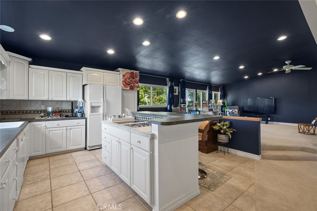 15241 Lille Circle Irvine, CA 92604 - Photo 26 of 38 a kitchen with stainless steel appliances kitchen island granite countertop a refrigerator a stove top oven and sink