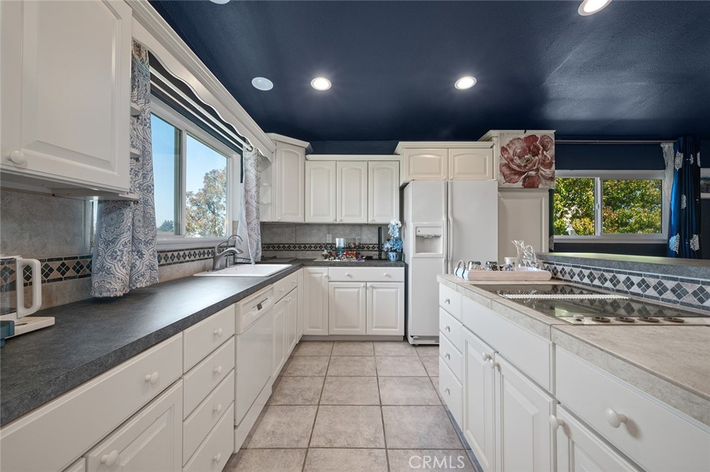 15241 Lille Circle Irvine, CA 92604 - Photo 27 of 38 a kitchen with stainless steel appliances granite countertop a sink and cabinets with wooden floor