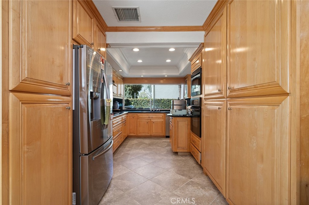 15241 Lille Circle Irvine, CA 92604 - Photo 7 of 38 a kitchen with stainless steel appliances a refrigerator and cabinets