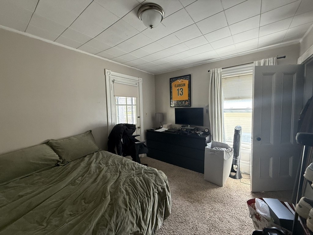4 Barstow Street Boston, MA 02134 - Photo 12 of 21 a bedroom with a bed and dresser with mirror