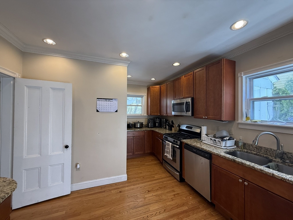 4 Barstow Street Boston, MA 02134 - Photo 3 of 21 a kitchen with stainless steel appliances granite countertop a stove top oven a sink dishwasher and a refrigerator with wooden floor