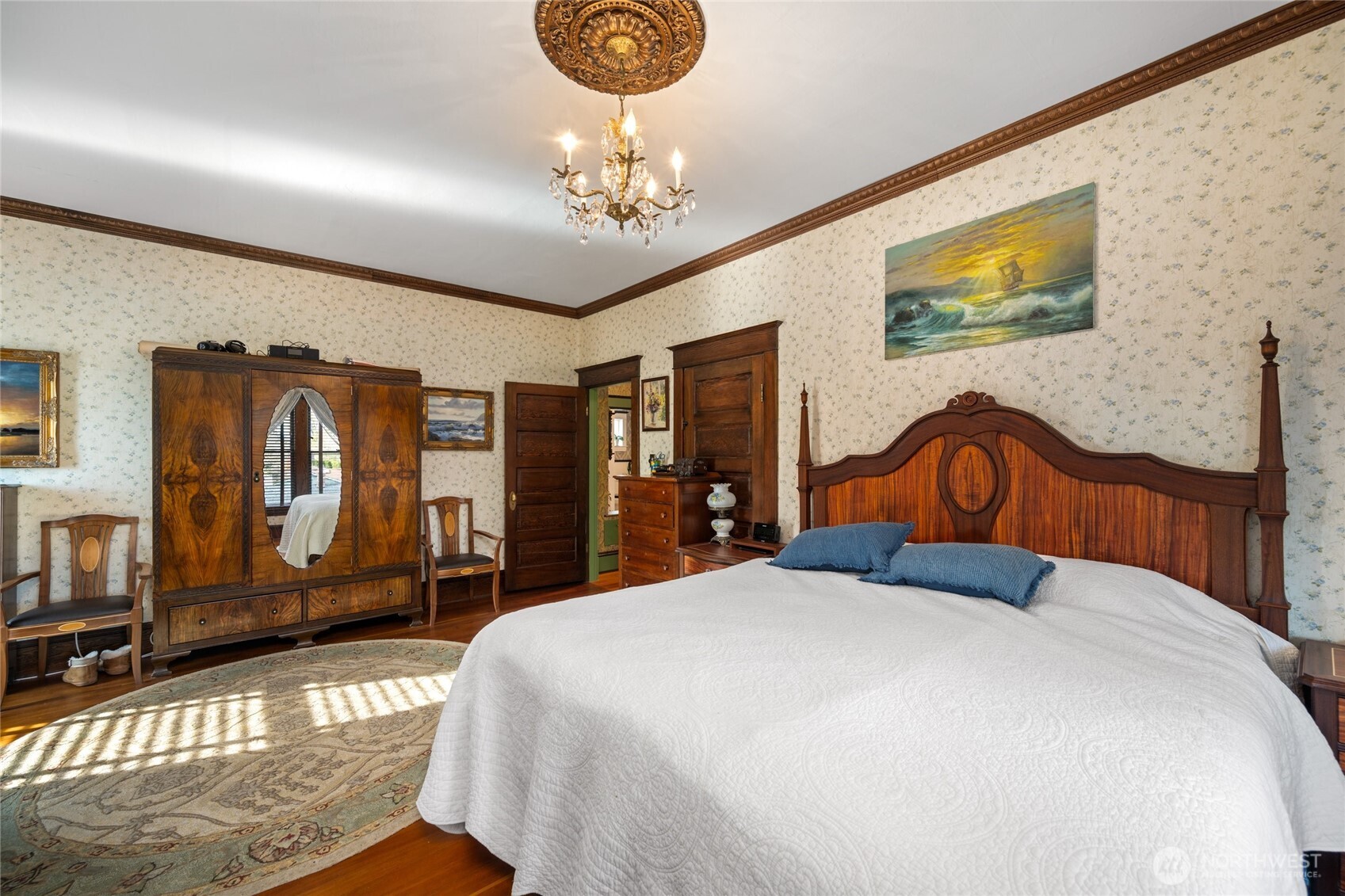 1507 15th Street Anacortes, WA 98221 - Photo 12 of 40 a bedroom with a large bed and a chandelier