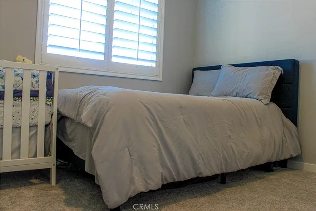 a bed sitting in a bedroom next to a window