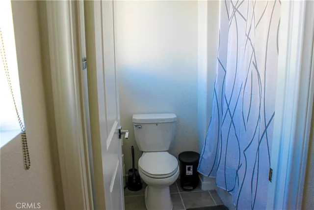 a white toilet sitting next to a shower
