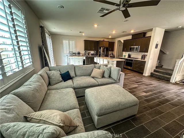 a living room with furniture kitchen view and a window