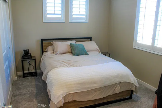 a bedroom with a bed and windows