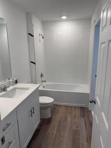 a white toilet sitting next to a shower