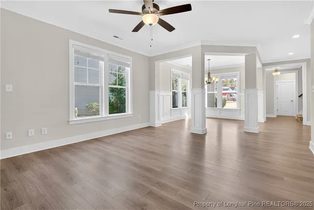 a view of an empty room with window and wooden floor