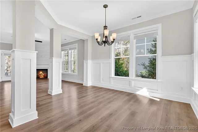a view of a livingroom with wooden floor a ceiling fan and windows