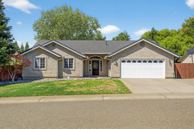 a front view of a house with a yard and garage