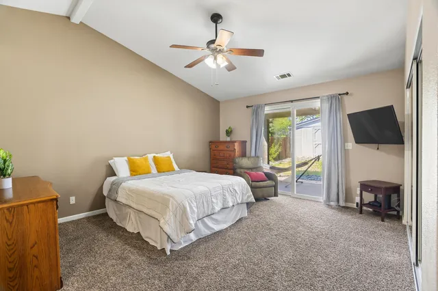 a bedroom with a bed a flat screen tv and a couch