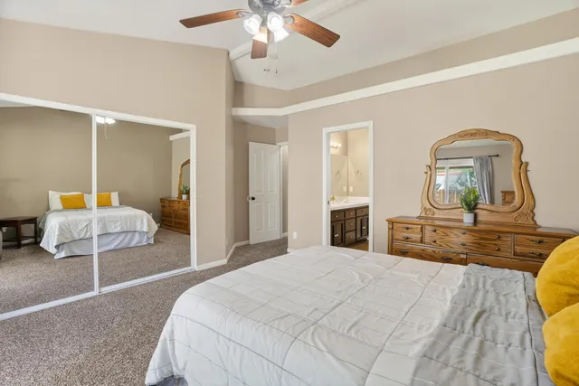 a bedroom with a bed a chandelier and dresser