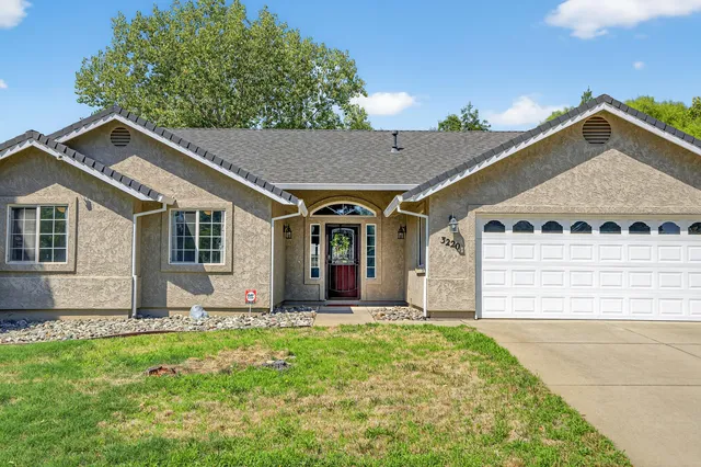 a view of a house with yard and tree s