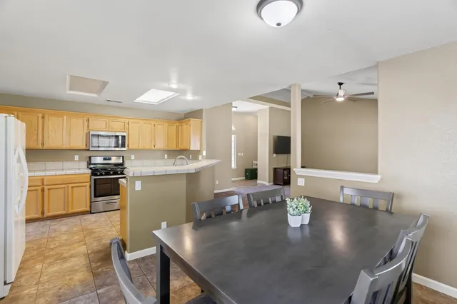a kitchen with a table chairs sink and cabinets