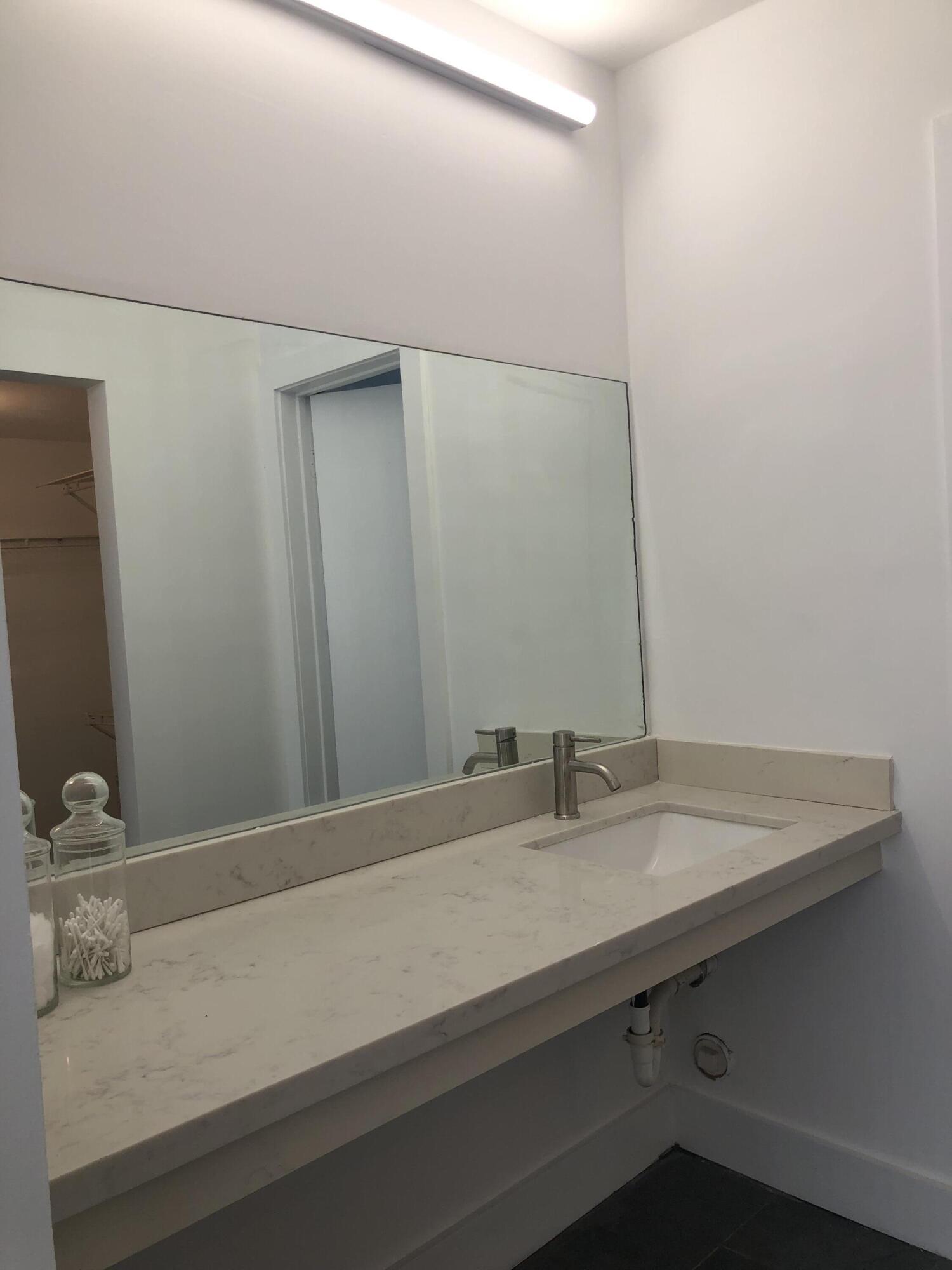 6850 Royal Palm Boulevard, Unit 104G Margate, FL 33063 - Photo 11 of 17 a bathroom with a sink and a mirror