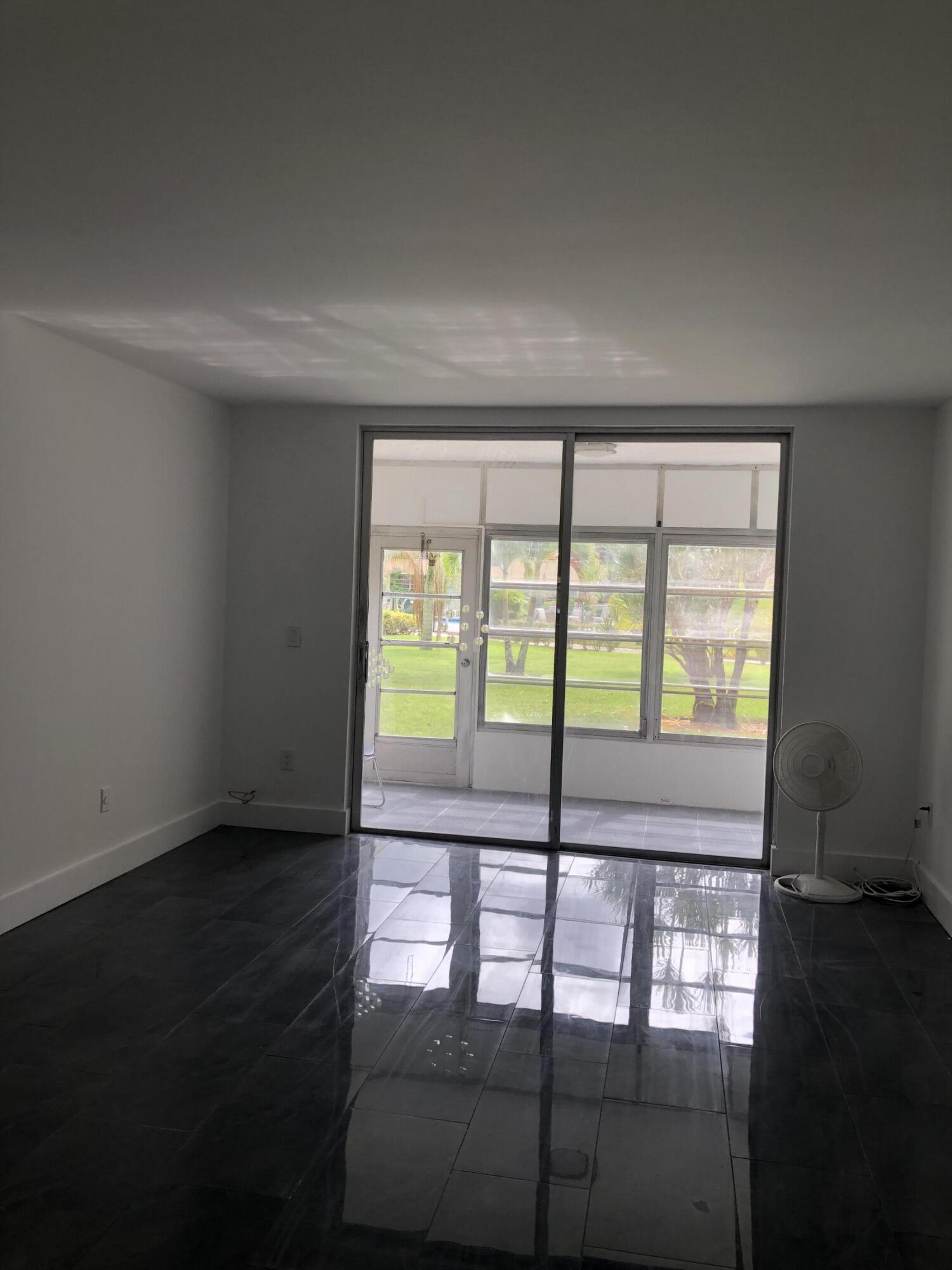 6850 Royal Palm Boulevard, Unit 104G Margate, FL 33063 - Photo 3 of 17 a view of an empty room with wooden floor and a window