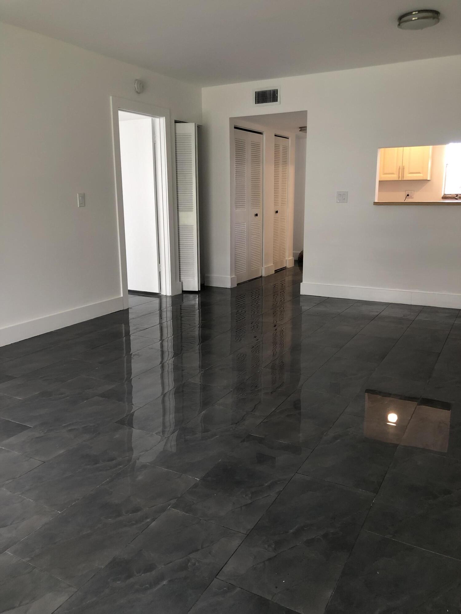 6850 Royal Palm Boulevard, Unit 104G Margate, FL 33063 - Photo 5 of 17 an empty room with wooden floor and windows