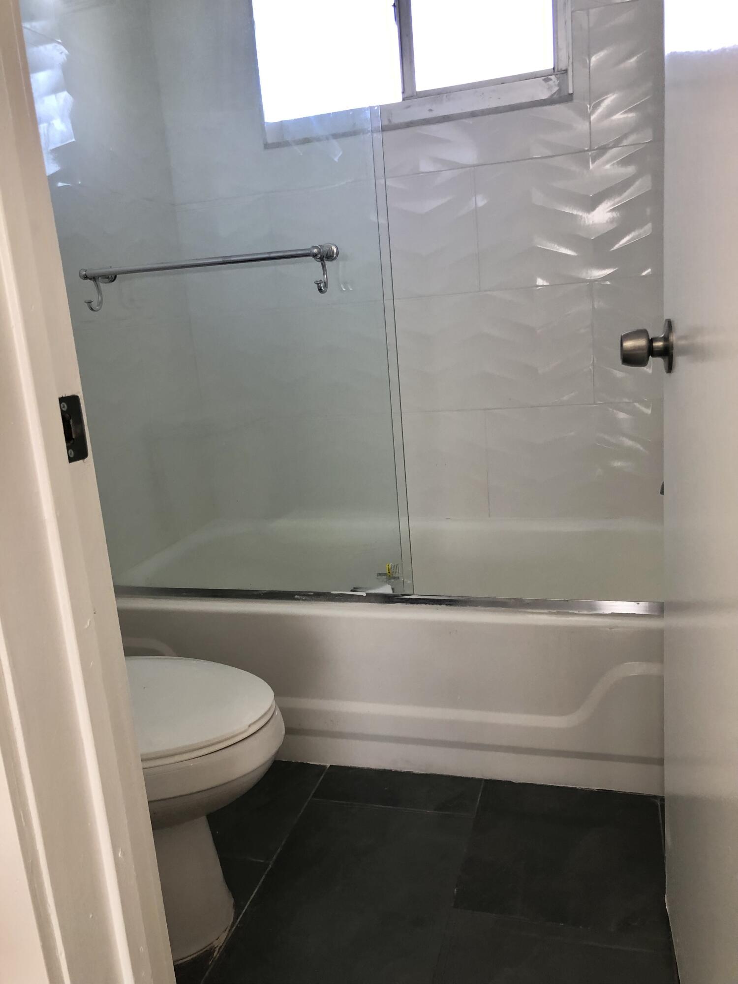 6850 Royal Palm Boulevard, Unit 104G Margate, FL 33063 - Photo 9 of 17 a bathroom with a bathtub and a toilet