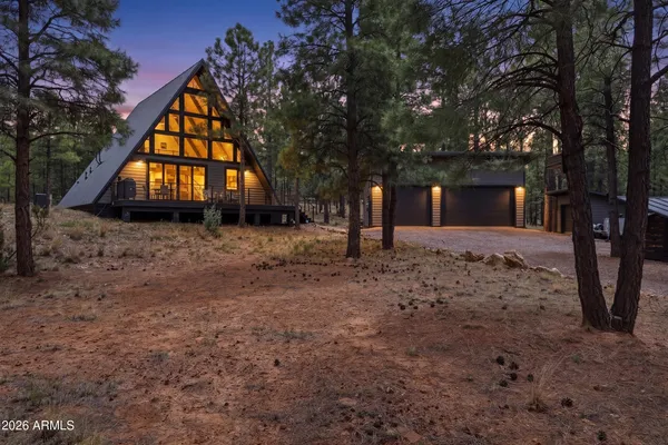 a backyard of a house with wooden fence and a large tree