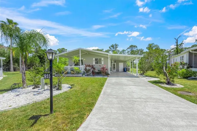 a view of house in front of a big yard with large trees