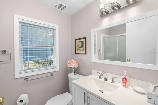 a bathroom with a sink vanity mirror and toilet
