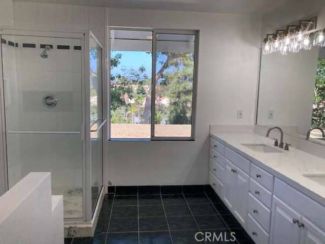 a bathroom with a double vanity sink toilet and shower