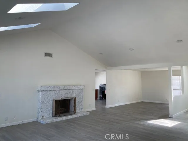 a view of empty room with wooden floor and fireplace