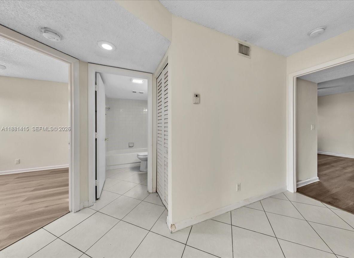 5661 Riverside Drive, Unit 101B7 Coral Springs, FL 33067 - Photo 21 of 49 a bathroom with a granite countertop mirror and a toilet