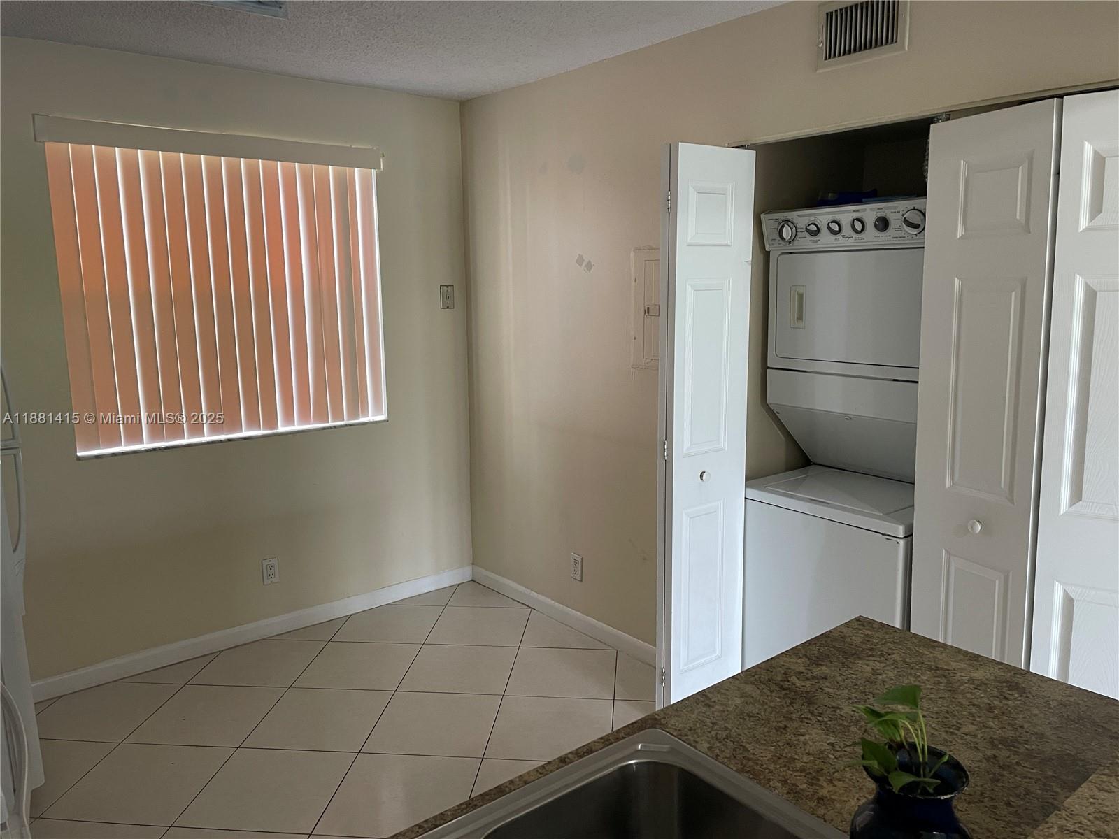5661 Riverside Drive, Unit 101B7 Coral Springs, FL 33067 - Photo 21 of 60 a kitchen with a refrigerator and cabinets