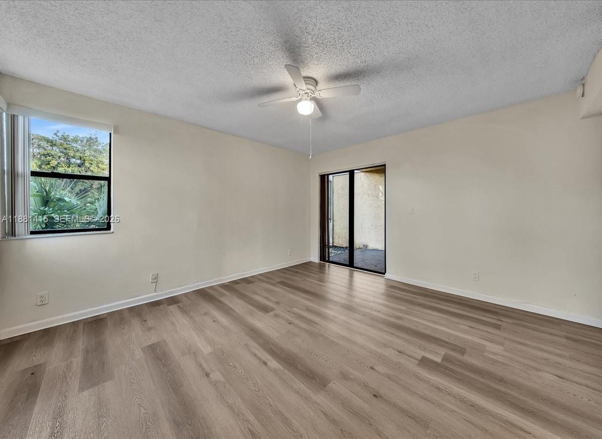 5661 Riverside Drive, Unit 101B7 Coral Springs, FL 33067 - Photo 25 of 49 a view of an empty room with wooden floor and a window