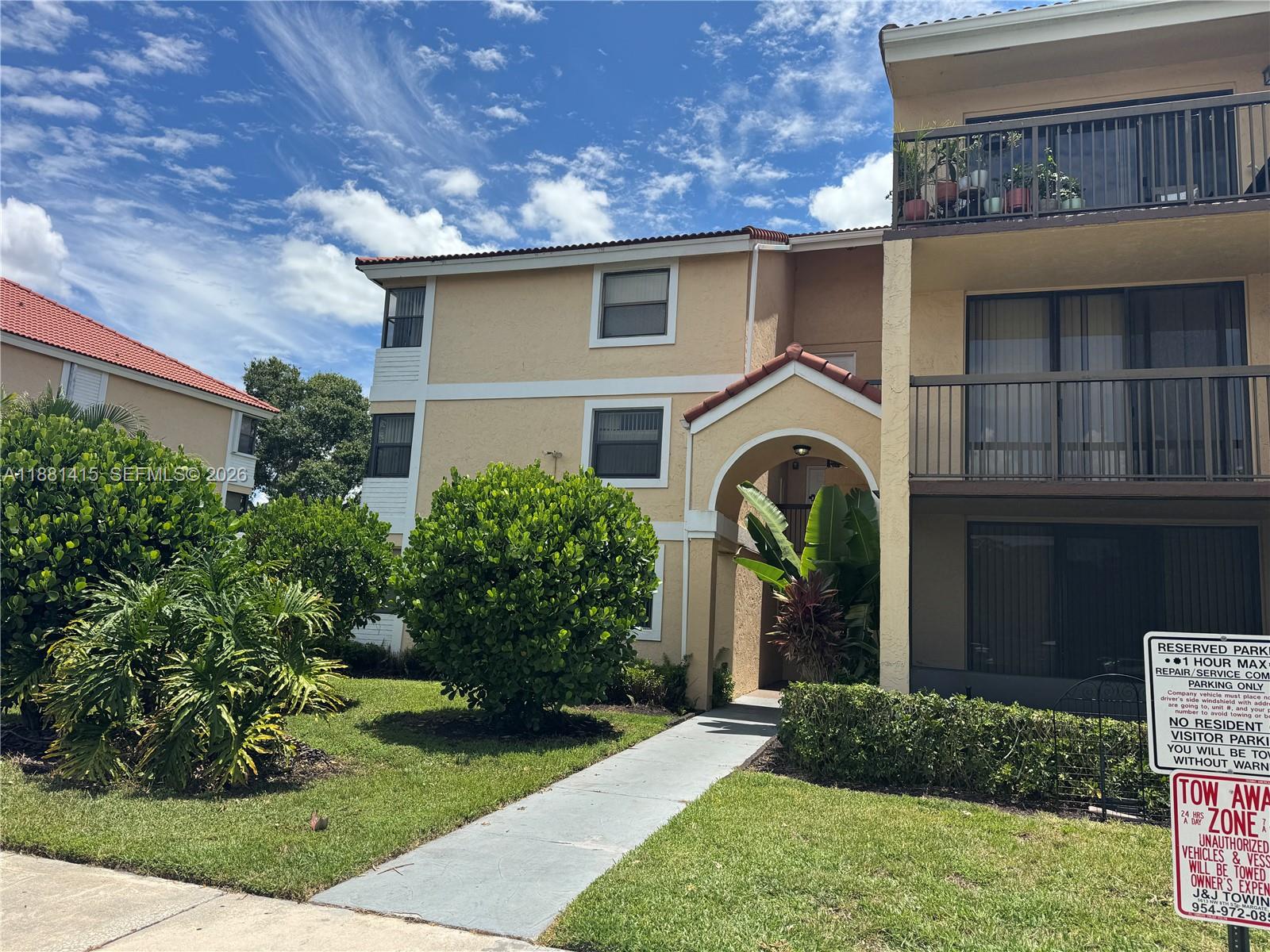 5661 Riverside Drive, Unit 101B7 Coral Springs, FL 33067 - Photo 3 of 49 a front view of a house with a garden