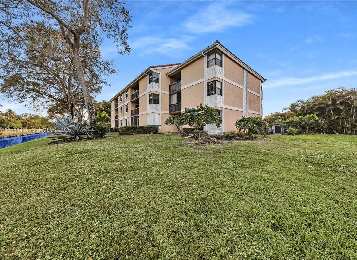 5661 Riverside Drive, Unit 101B7 Coral Springs, FL 33067 - Photo 34 of 49 a front view of a house with a yard