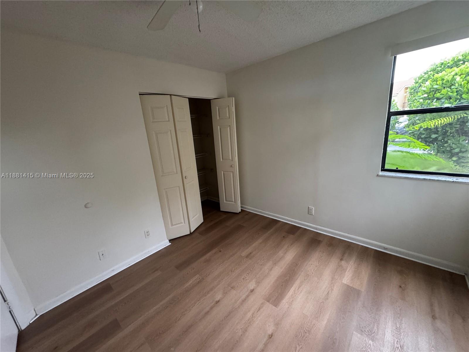 5661 Riverside Drive, Unit 101B7 Coral Springs, FL 33067 - Photo 34 of 60 an empty room with wooden floor and windows