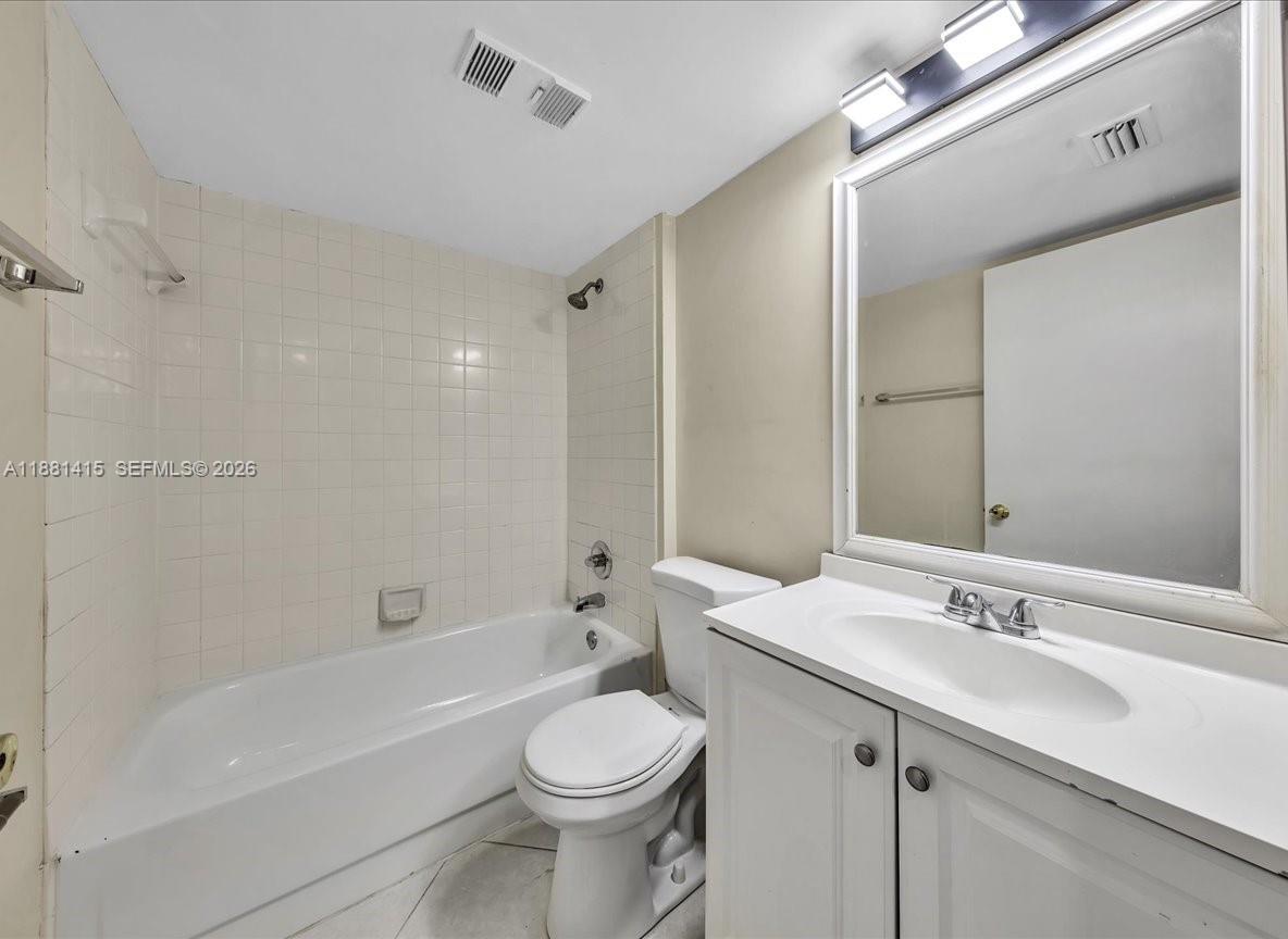 5661 Riverside Drive, Unit 101B7 Coral Springs, FL 33067 - Photo 37 of 49 a bathroom with a sink a toilet a mirror and bathtub