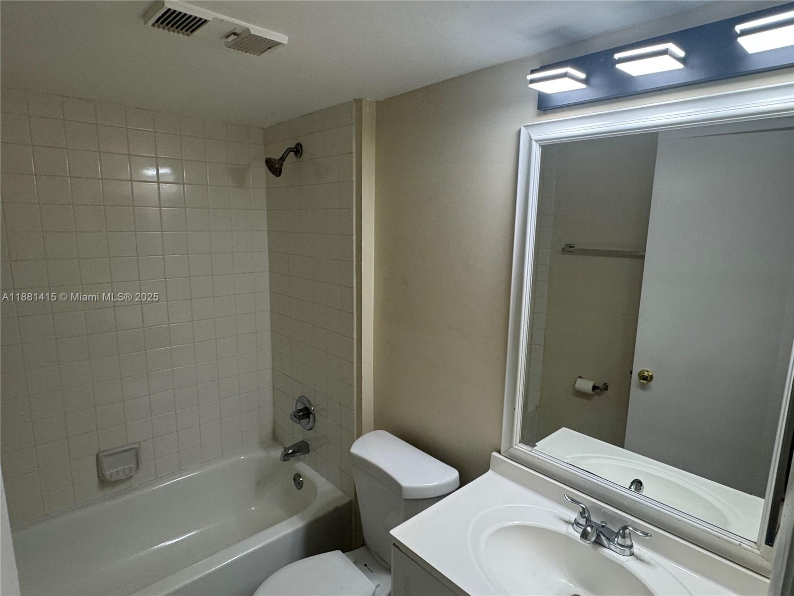 5661 Riverside Drive, Unit 101B7 Coral Springs, FL 33067 - Photo 38 of 60 a bathroom with a sink and mirror with toilet