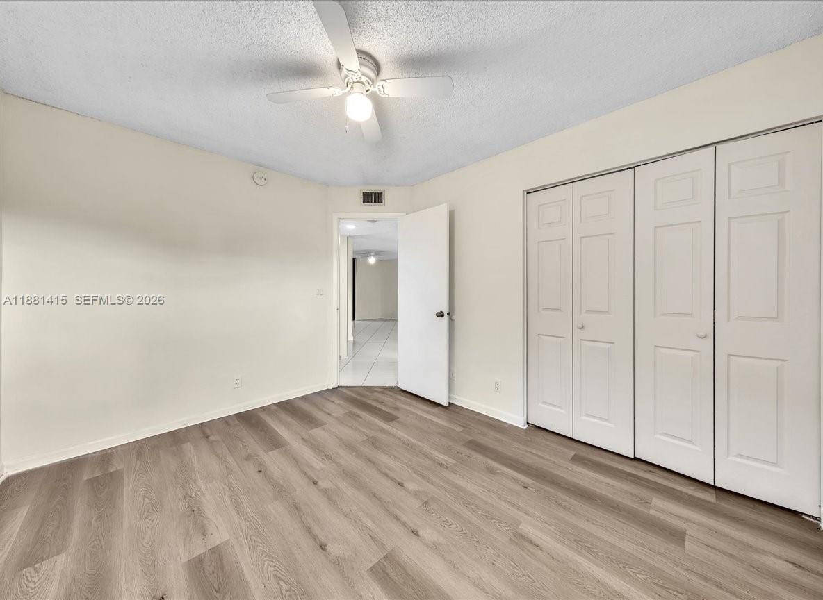 5661 Riverside Drive, Unit 101B7 Coral Springs, FL 33067 - Photo 40 of 49 a view of an empty room with wooden floor