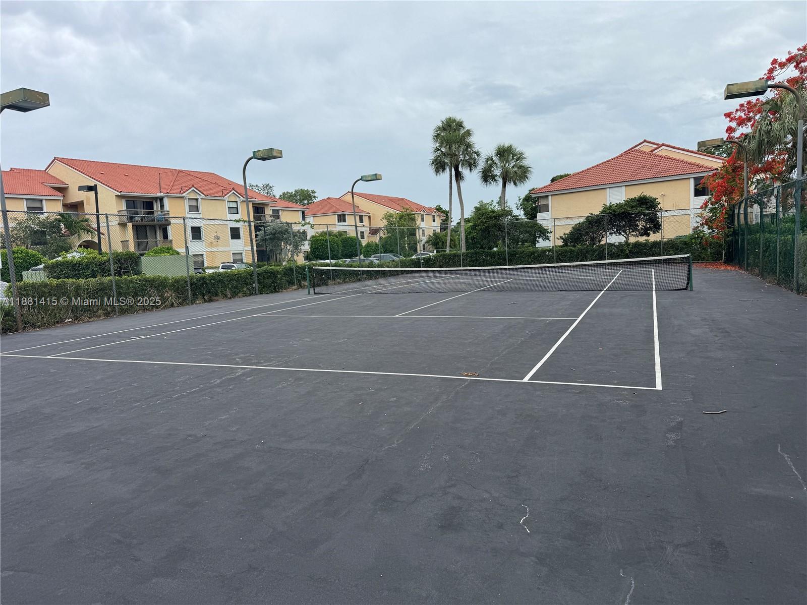 5661 Riverside Drive, Unit 101B7 Coral Springs, FL 33067 - Photo 48 of 60 a view of a tennis ground with a large trees